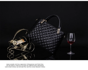 Detail of black quilted leather handbag with gold hardware next to a wine glass
