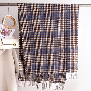 Detail of classic houndstooth scarf with fringe ends hanging in a lifestyle setting