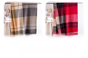 Detail view of plaid cashmere-like scarves in grey and red with soft fringe tassels