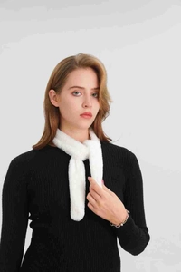 Close-up of white faux fur neck warmer scarf with soft texture and cross-loop closure