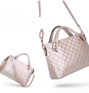 Detail of champagne gold quilted shoulder bag showing metal handles and detachable strap