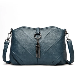 Sac bandoulière bleu-gris matelassé avec coutures en V et pendentif anneau à pompons