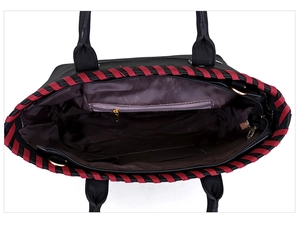Top view of spacious black tote bag interior with red woven trim and zipper pocket