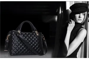 Detailed close-up of a black quilted leather tote bag featuring gold-tone hardware
