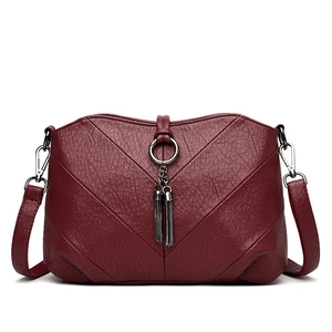 Sac bandoulière bordeaux classique pour femme avec pompon et texture cuir grainé