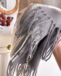 Close-up of classic grey and beige plaid scarf with fringed edges and soft twill texture