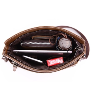 Brown leather crossbody bag interior showing spacious compartments and zip pocket storage