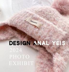 Close-up of pink knit balaclava hat with fluffy pompom and branded woven label