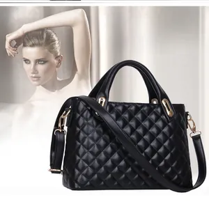 Detail of black quilted shoulder bag with gold hardware and adjustable strap