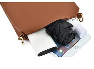 Vista interna che mostra la grande capacità della borsa a tracolla marrone con oggetti