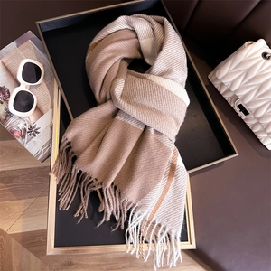 Detail of checkered plaid scarf with fringe accents beside fashion accessories