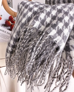 Close-up of grey houndstooth pattern scarf with soft fringe and stylish winter detail
