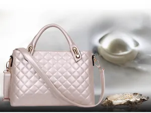 Detail of champagne gold quilted handbag with pearl luster finish and golden metal handle