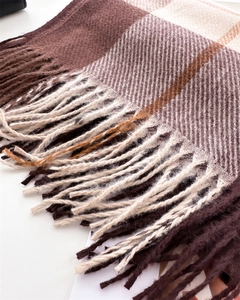 Close-up of checkered scarf showing fine texture and long tassels in autumn colors