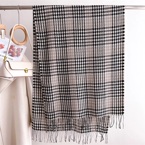 Detailed view of soft black and white plaid scarf featuring elegant long tassel fringe
