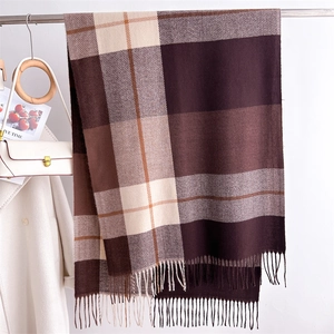 Detail of classic plaid scarf with fringe accents in brown and beige tones