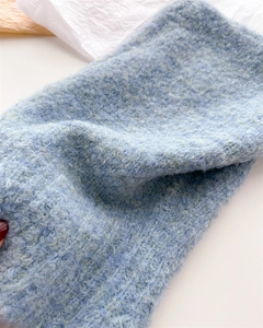 Dettaglio del tessuto in maglia bouclé azzurro per passamontagna invernale