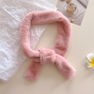 Pink faux fur scarf with cross-pull design for women, soft plush neck warmer on a desk