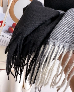Macro detail of thick woven plaid scarf with fringe tassels and soft knitted texture