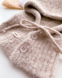 Dettaglio del passamontagna in lana sherpa beige con coulisse e consistenza morbida