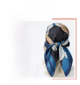 Detailed pattern of a 90cm floral silk scarf in elegant peacock blue and beige