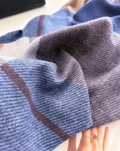 Close-up of thick cashmere-like fabric showing blue beige plaid pattern and texture