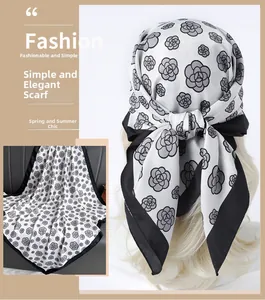 Detail of silk-like square scarf featuring elegant black and white camellia floral prints