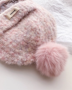 Detail of pink knitted balaclava with soft pom-pom and woven brand label