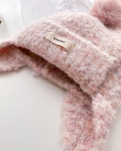 Detail of pink bouclé knit balaclava with soft texture and white brand logo label