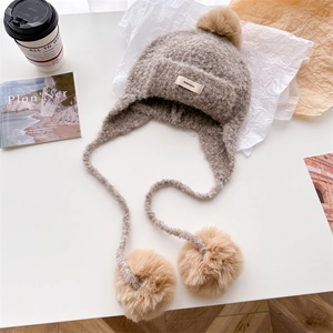 Chic beige balaclava knit hat with faux fur pom-poms and warm ear flaps for winter wear
