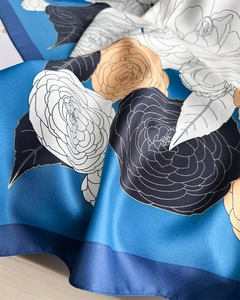 Detail of silk scarf showing blue camellia floral prints and elegant twill fabric texture