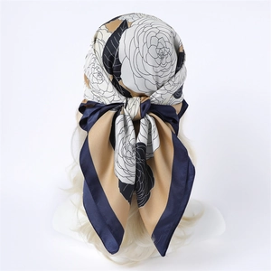 Detail of elegant floral silk scarf tied on mannequin head with gold hair and navy border