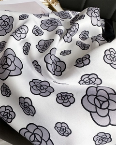 Detail of silk scarf with floral pattern showing smooth texture and satin finish