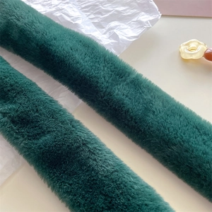 Close-up of soft dark green faux fur scarf with dense texture and plush quality