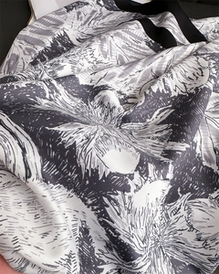 Gros plan d'un foulard en soie montrant un imprimé floral et une texture sergée