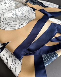 Detail of silk-like twill scarf showing elegant floral print and luxury fabric texture