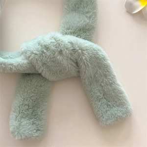 Close-up of a soft mint green faux fur scarf with a plush texture and cross-knot design