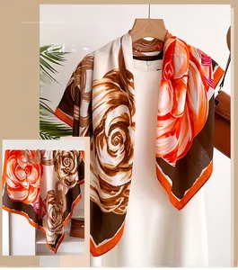 Detail view of floral silk scarf featuring large orange and brown rose patterns
