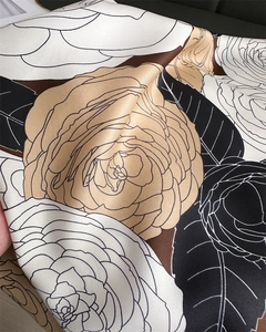 Macro shot of silk-like satin twill scarf showing elegant floral print and fine texture