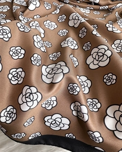 Detailed close-up of mocha brown twill silk scarf with white camellia flower patterns