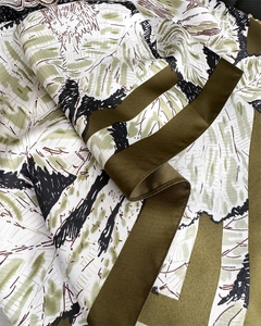 Macro d'un foulard en soie vert olive avec texture sergée et motifs abstraits dessinés
