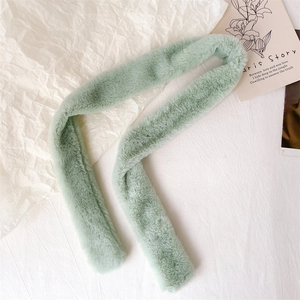 Close-up of mint green faux fur scarf showing soft plush texture on white background