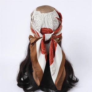 Detail of floral silk scarf tied on head with red rose pattern and smooth texture