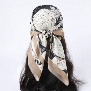 Vue détaillée d'un foulard en soie à fleurs noué sur des cheveux bouclés