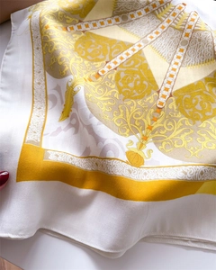 Detail eines Seidenschals mit barocken Goldmustern und eleganter Köperstofftextur