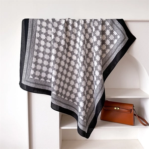 Dettaglio di un lussuoso foulard in seta bianco e nero con motivi a catena geometrici esposti