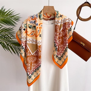 Retro baroque print silk scarf in orange and tan displayed on a summer dress