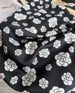 Detailed view of white camellia floral print on black twill satin scarf fabric