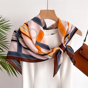 Klassisches Seidentuch mit Kettenmuster über einem weißen Kleid für einen eleganten Look