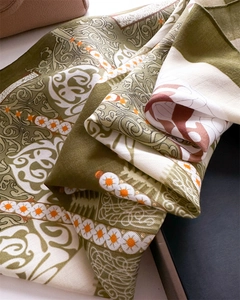 Detail eines Seidenschals in Olivgrün mit Paisley-Muster und Fischgrätenstruktur